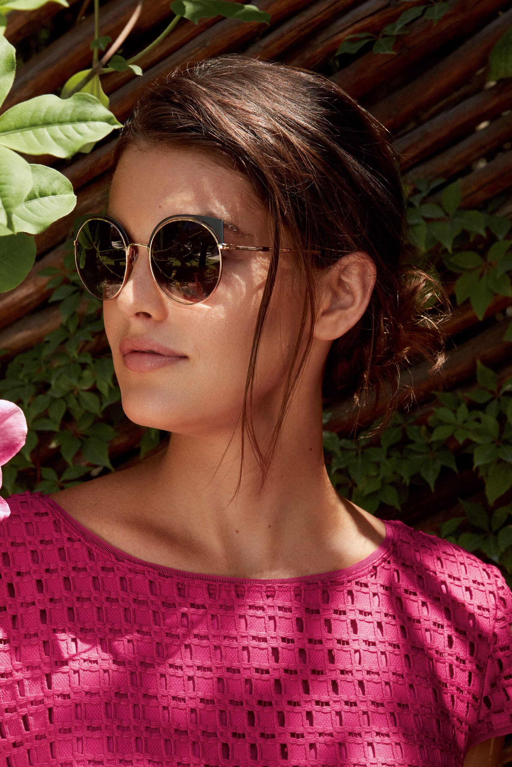 Woman wearing a pink top and sunglasses